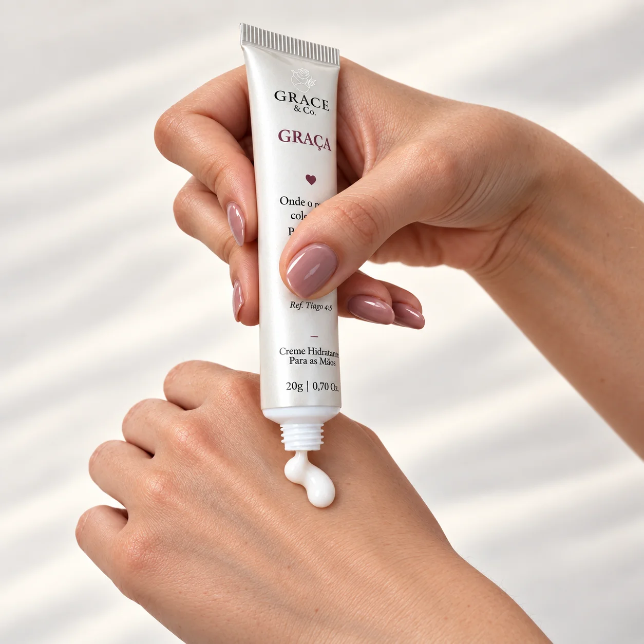 Bisnaga do Creme Hidratante Grace sendo apertada sobre a mão